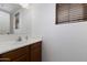Bright bathroom featuring a large mirror, single sink vanity and window at 451 S Hawes Rd # 53, Mesa, AZ 85208