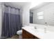 Well-lit bathroom features a shower with blue curtain, vanity, and a large mirror for added convenience at 451 S Hawes Rd # 53, Mesa, AZ 85208