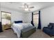 Bright bedroom with a ceiling fan, blue bedding, and two windows at 451 S Hawes Rd # 53, Mesa, AZ 85208