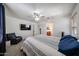 Bedroom featuring walk-in closet, ensuite bathroom, ceiling fan, and large television at 451 S Hawes Rd # 53, Mesa, AZ 85208