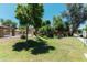 Community pool area features a grass lawn, mature trees, and seating at 451 S Hawes Rd # 53, Mesa, AZ 85208