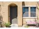 Close-up of a home's inviting front door and porch area, complete with bench and potted plants at 451 S Hawes Rd # 53, Mesa, AZ 85208