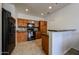 Well-lit kitchen featuring wood cabinets, black appliances, and tile flooring at 451 S Hawes Rd # 53, Mesa, AZ 85208