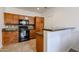 Kitchen boasts wood cabinetry, black appliances, and stylish countertops at 451 S Hawes Rd # 53, Mesa, AZ 85208