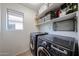 Practical laundry room equipped with modern washer and dryer units, shelving for storage at 451 S Hawes Rd # 53, Mesa, AZ 85208