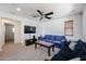 Comfortable living room with bright white walls, neutral carpet, dark TV console, and two sofas at 451 S Hawes Rd # 53, Mesa, AZ 85208