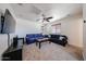 Spacious living room with neutral carpet, modern ceiling fan, flat screen TV, and two sofas at 451 S Hawes Rd # 53, Mesa, AZ 85208