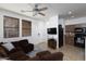 Cozy living room featuring a plush brown sofa, tile floors, and natural light, adjacent to the kitchen at 451 S Hawes Rd # 53, Mesa, AZ 85208