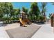 Community playground featuring mature shade trees and a yellow climbing structure with slides at 451 S Hawes Rd # 53, Mesa, AZ 85208