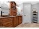 Bathroom with double sinks, custom wood cabinets, and a linen tower at 5402 E Mckellips Rd # 237, Mesa, AZ 85215