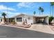 Charming home with a covered carport, well-manicured landscaping, and mature palm trees enhancing curb appeal at 5402 E Mckellips Rd # 237, Mesa, AZ 85215