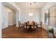 Formal dining room with hardwood floors, a round wooden table, and large windows providing natural light at 5832 E Bent Tree Dr, Scottsdale, AZ 85266