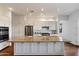 Bright white kitchen featuring stainless steel appliances, a large island with granite countertops, and hardwood floors at 5832 E Bent Tree Dr, Scottsdale, AZ 85266