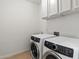 This laundry room features front loading washer and dryer, and white cabinets for storage at 5832 E Bent Tree Dr, Scottsdale, AZ 85266
