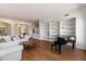 Open living room with hardwood floors, white sofas, arched doorways, a grand piano, and built in shelving at 5832 E Bent Tree Dr, Scottsdale, AZ 85266