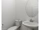 This powder room features a pedestal sink and round mirror, creating a clean and modern space at 5832 E Bent Tree Dr, Scottsdale, AZ 85266