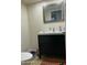 A sleek half bathroom featuring a modern vanity, stylish mirror, and tiled flooring at 618 E Manzanita Pl, Phoenix, AZ 85020