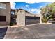 Two car garage with a black door and stucco siding, with an attached front parking area at 618 E Manzanita Pl, Phoenix, AZ 85020