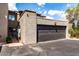 Two car garage with a black door and stucco siding, with an attached front parking area at 618 E Manzanita Pl, Phoenix, AZ 85020