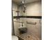 A tiled shower stall featuring dual shower heads, seating, and grab bars for accessibility and comfort at 618 E Manzanita Pl, Phoenix, AZ 85020