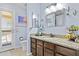 Bathroom vanity with granite countertop, wood cabinets, soft blue walls, and desert themed decor at 6249 E Camelot Dr, Mesa, AZ 85215