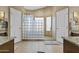 Well-lit bathroom showcasing a unique glass block shower and neutral tile flooring at 6249 E Camelot Dr, Mesa, AZ 85215