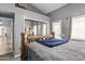 Bedroom featuring log bed frame, neutral grey walls, mirrored closet door and natural light from the window at 6249 E Camelot Dr, Mesa, AZ 85215