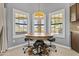 Bright breakfast nook featuring a round table, saddle barstools, and large windows at 6249 E Camelot Dr, Mesa, AZ 85215