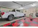Spacious garage featuring ample storage, red and black checkerboard flooring, and a white pickup truck at 6249 E Camelot Dr, Mesa, AZ 85215