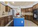 Well-lit kitchen featuring stainless appliances, wooden cabinets, and center island at 6249 E Camelot Dr, Mesa, AZ 85215