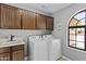 Charming laundry area equipped with washer, dryer, neutral paint, and convenient utility sink at 6249 E Camelot Dr, Mesa, AZ 85215