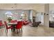 A bright open living room with a dining area that has a table with red chairs and wood flooring at 6249 E Camelot Dr, Mesa, AZ 85215
