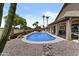 Home's sparkling swimming pool with desert landscaping, complemented by a covered patio for relaxation and entertainment at 6249 E Camelot Dr, Mesa, AZ 85215
