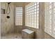 Stylish shower with glass block windows, built-in seat, and updated fixtures at 6249 E Camelot Dr, Mesa, AZ 85215