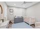 Neutral baby bedroom featuring shutters, crib, and gray dresser at 6721 N 14Th Pl, Phoenix, AZ 85014