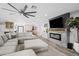 Stylish living room featuring a modern fireplace, sleek ceiling fan, and seamless flow to the dining area at 6721 N 14Th Pl, Phoenix, AZ 85014