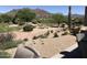 Lush backyard featuring a water feature, golf course access, desert landscaping, and picturesque mountain views at 6917 E Night Glow Cir, Scottsdale, AZ 85266