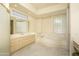 Bright primary bathroom with a large soaking tub and a glass block window at 6917 E Night Glow Cir, Scottsdale, AZ 85266