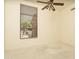 Neutral bedroom with a ceiling fan and a window looking out to the backyard at 6917 E Night Glow Cir, Scottsdale, AZ 85266