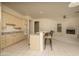 Cozy kitchen featuring light-colored cabinets, tile floors, a breakfast bar, and views of the living room at 6917 E Night Glow Cir, Scottsdale, AZ 85266