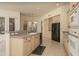 Functional kitchen featuring tile floors, light cabinets, a breakfast bar, and modern appliances at 6917 E Night Glow Cir, Scottsdale, AZ 85266