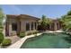 Backyard view of freeform pool with mature landscaping and the home's exterior at 6917 E Night Glow Cir, Scottsdale, AZ 85266