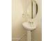 Neutral powder room with pedestal sink, round mirror, and tile flooring at 6917 E Night Glow Cir, Scottsdale, AZ 85266