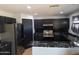Modern kitchen featuring black cabinets, stainless steel appliances, and striking black marble countertops at 7224 W Pioneer St, Phoenix, AZ 85043