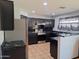 Modern kitchen featuring black cabinets, stainless steel appliances, and striking black marble countertops at 7224 W Pioneer St, Phoenix, AZ 85043