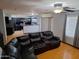 Open concept living room with laminate wood flooring open to the kitchen and natural light at 7224 W Pioneer St, Phoenix, AZ 85043
