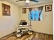 Bedroom with light wood laminate flooring, white walls, desk, and natural light at 7940 W Avalon Dr, Phoenix, AZ 85033