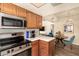 Cozy kitchen featuring stainless steel appliances, wooden cabinetry, and modern countertops overlooking dining area at 839 S Westwood -- # 287, Mesa, AZ 85210