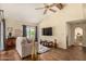 Bright living room featuring a large window, ceiling fan, neutral paint, wood floors, and a television at 839 S Westwood -- # 287, Mesa, AZ 85210