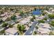 This aerial view captures a neighborhood with lush greenery, well-maintained homes, and a serene lake at 869 W Shellfish Dr, Gilbert, AZ 85233